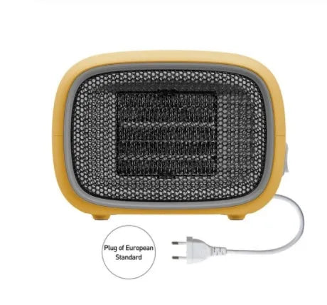 Compact green mini ceramic desk heater with metal mesh front grille, shown next to a pen for scale.