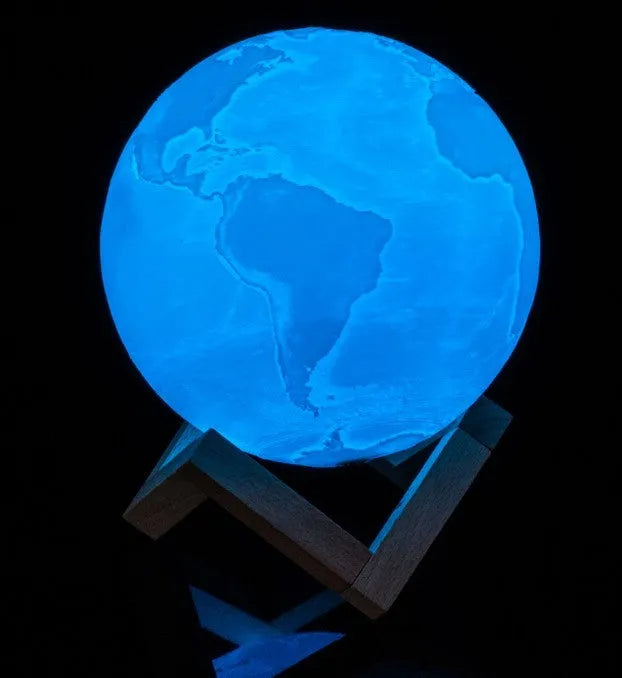 3D printed white moon lamp on wooden stand showing detailed lunar surface texture.