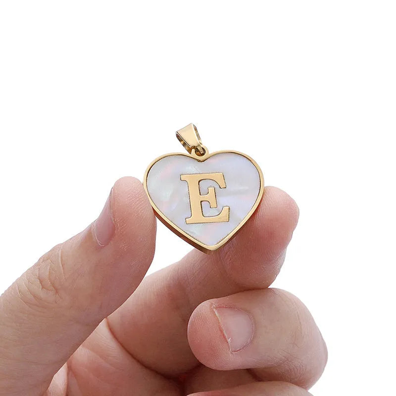 Gold-plated heart necklace with white shell pendant showing initial engraving on stainless steel chain