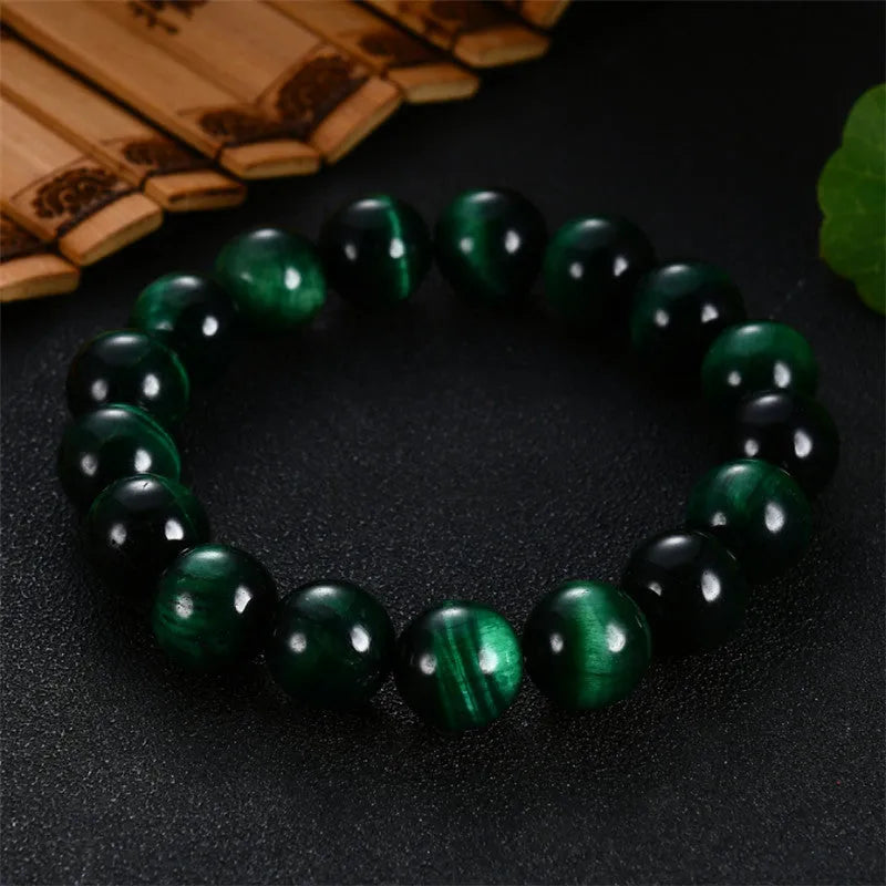 Green Tiger Eye stone geometric bead bracelet on wrist, showing polished surface and banding.