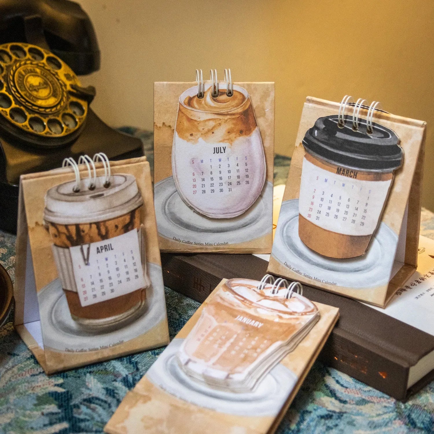 Mini coffee desk calendar 2025 with four design options on small desk surface