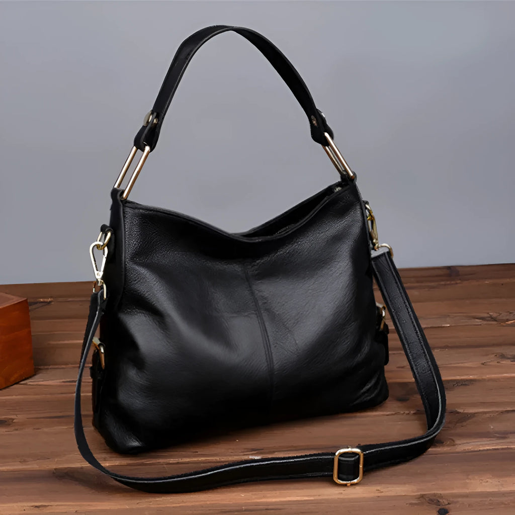 Genuine leather crossbody bag in a vertical square shape with visible sewing lines and a crossbody strap.