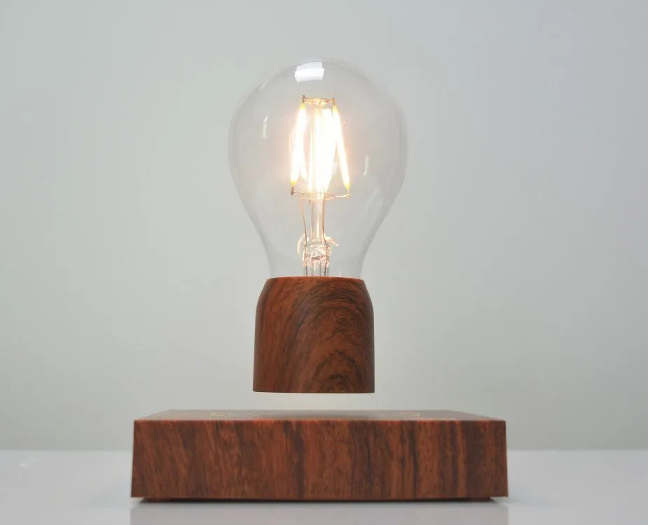 Magnetic levitation floating light bulb with imitation wood base on a table.