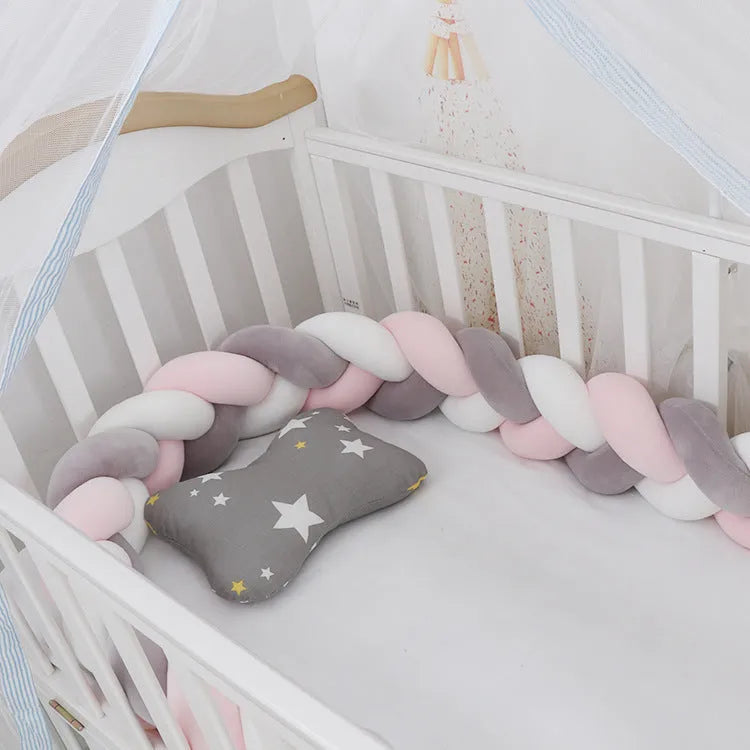 Braided knot pillow cushion bumper for infant crib in spandex velvet, shown in a light colour.