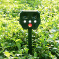 Green solar ultrasonic animal repeller unit with LED strobe lights for outdoor pest control.