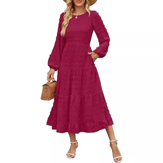A woman wearing a beige high waist long sleeve dress with ruffled sleeves, a round neck, and a solid colour design.