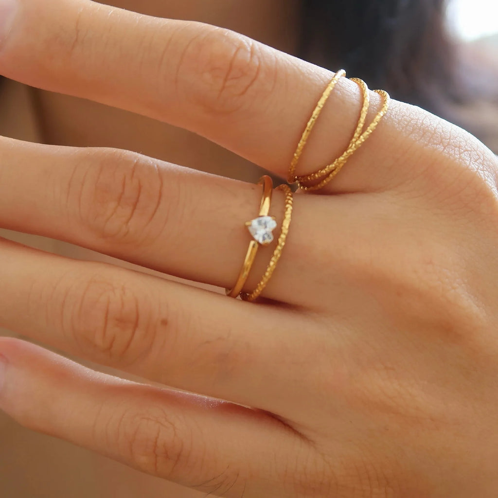 Golden heart-shaped stainless steel ring with electroplated finish shown in sizes 6, 7, and 8