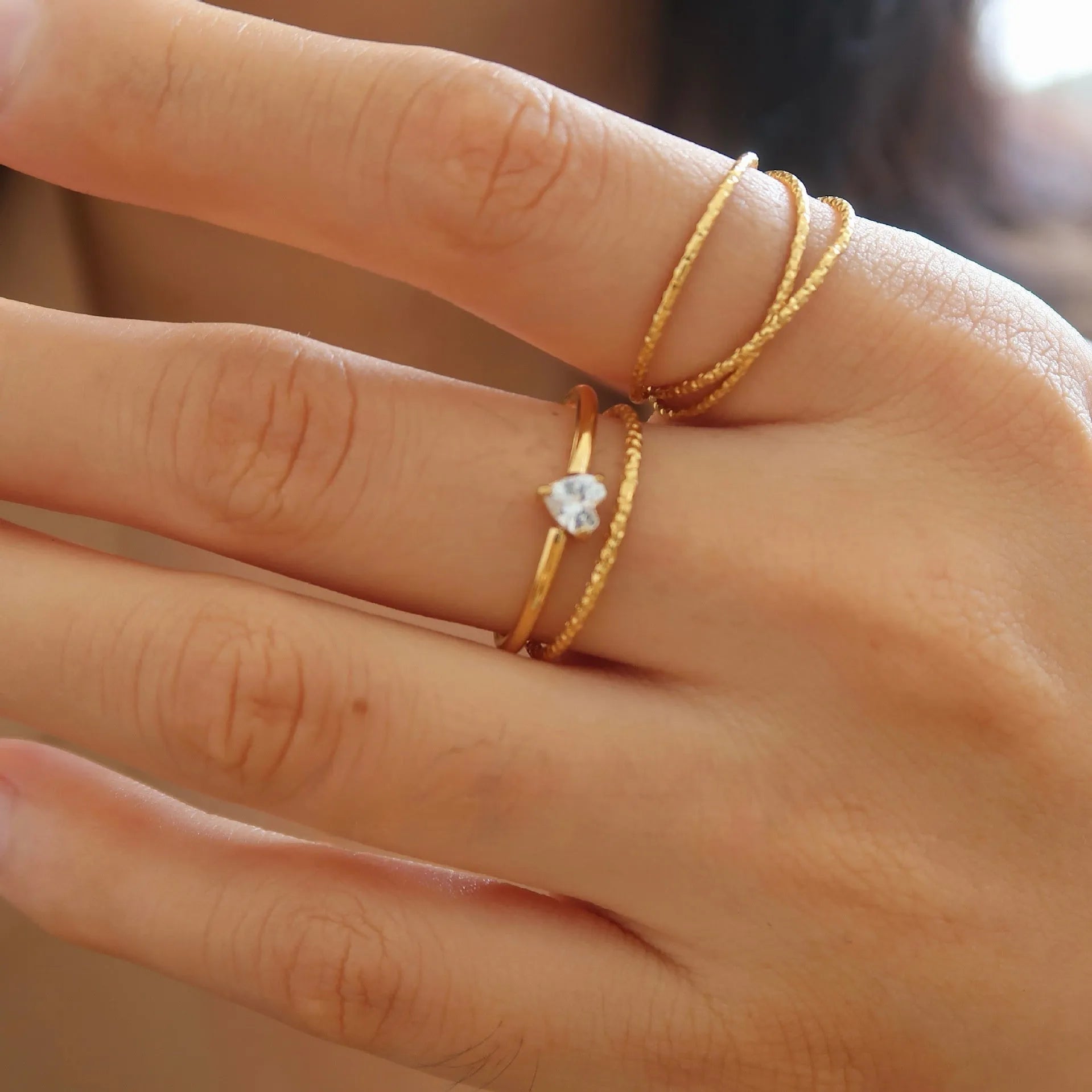 Golden heart-shaped stainless steel ring with electroplated finish shown in sizes 6, 7, and 8