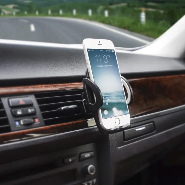 Black plastic mobile phone holder mounted on a car air conditioning vent