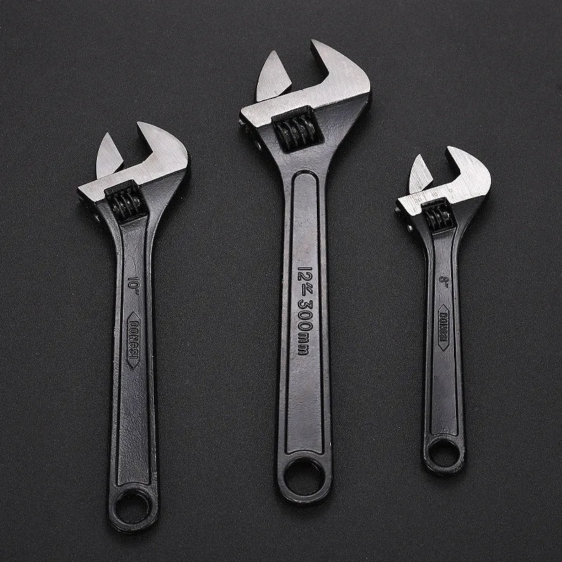 High carbon steel adjustable open-end wrench with blackened finish on a grey background.