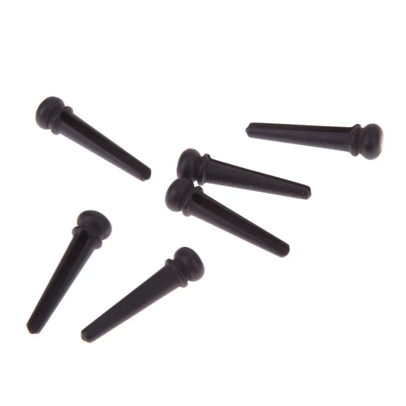 Six solid ebony guitar string nails with matt black finish for folk acoustic guitars.