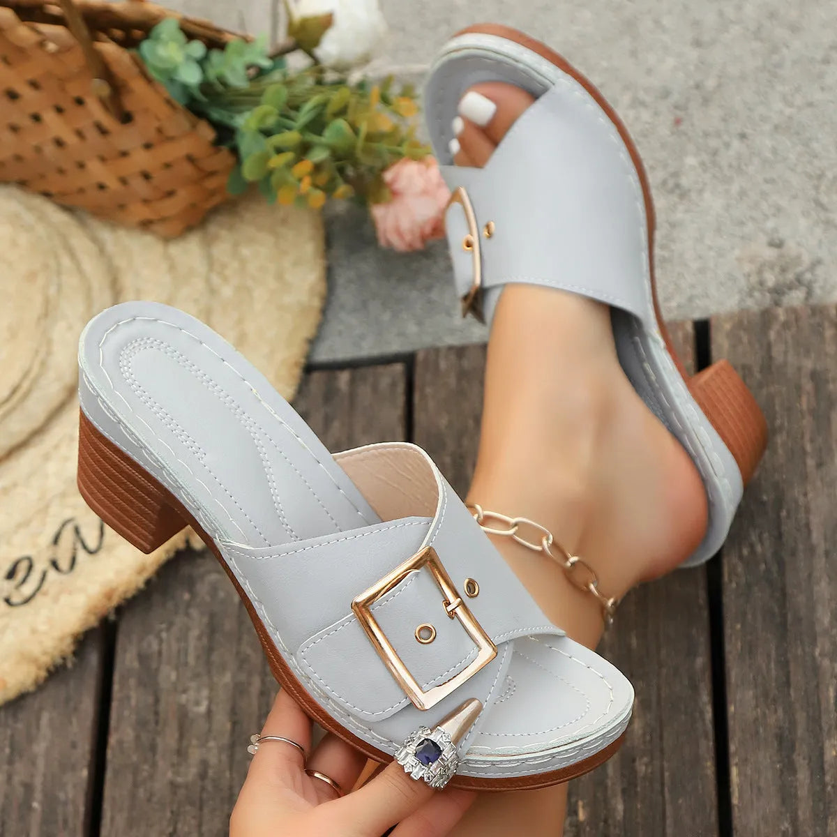 Women's black and light blue chunky heel slippers with a metal buckle closure on a rubber sole.