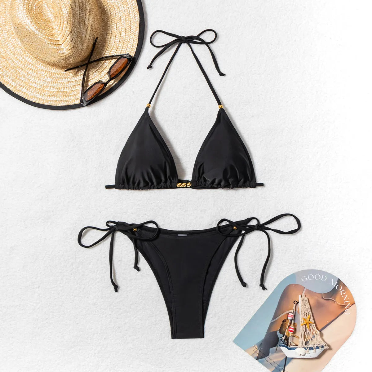 Black women's two-piece bikini swimsuit with metal bead detailing and split-style bottoms.