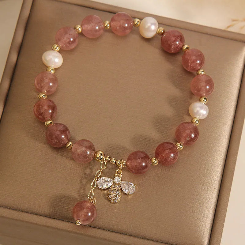 Women's bracelet with freshwater pearls, pink strawberry quartz stones, and a metallic zircon alloy clasp.