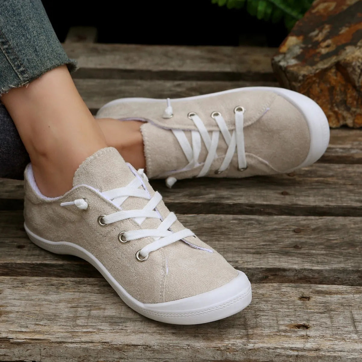 Creamy white low-top women's casual sneakers with a fabric upper and rubber sole.