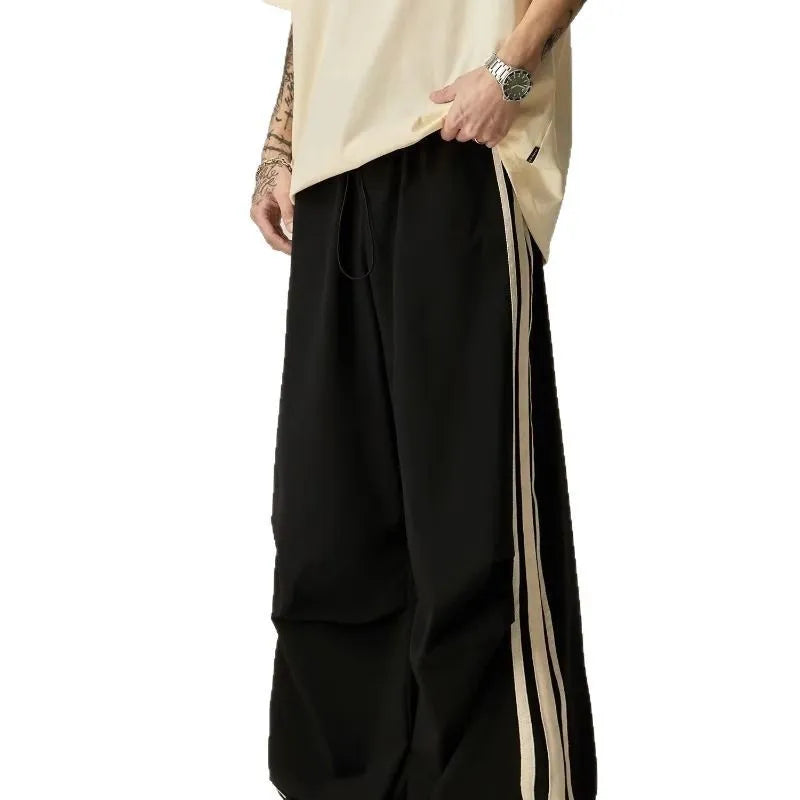 Black men's wide-leg high-waist climbing trousers laid flat, showing straight cut and polyester fabric.