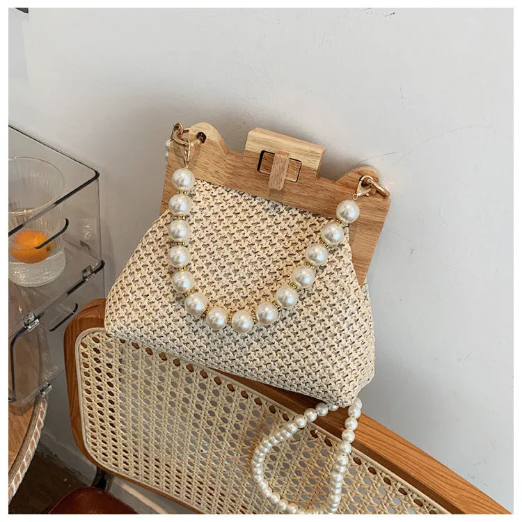 Women's straw woven shoulder bag with pearl chain detail in horizontal square shape