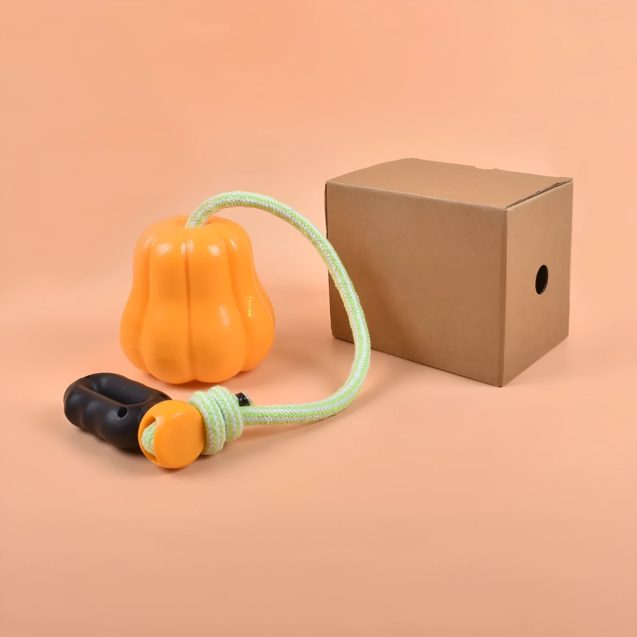 Large orange pumpkin-shaped plastic dog chew toy with an attached rope for throwing