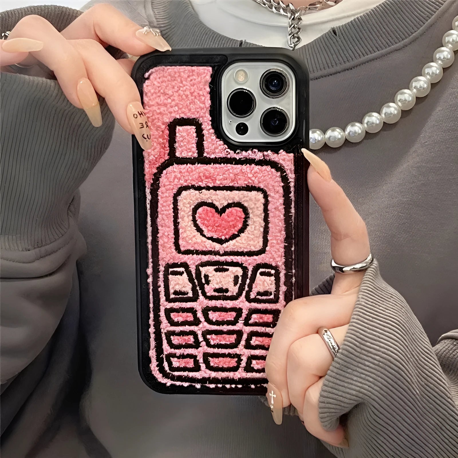 Pink TPU iPhone case with embroidered towel pattern design on the back.