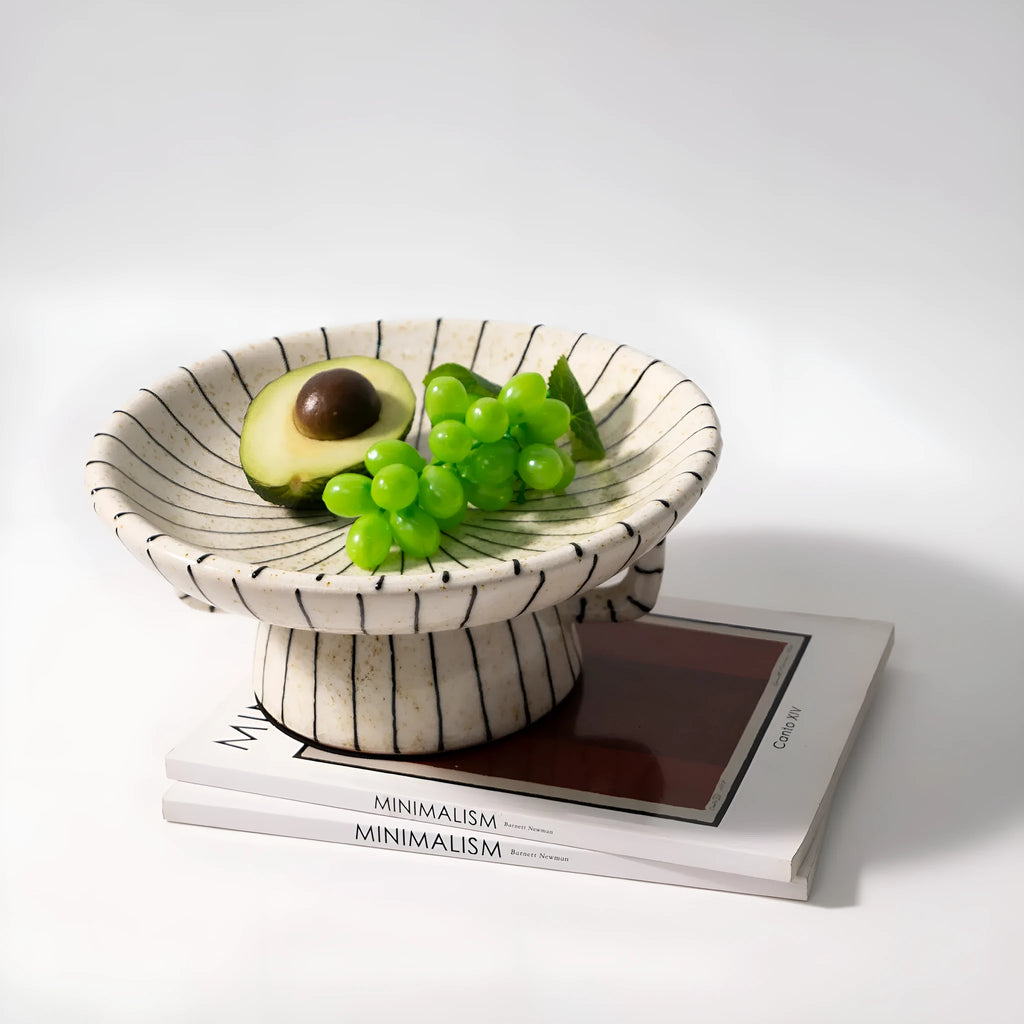 Black and white striped plastic resin fruit plate on a wooden surface.