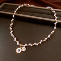 Gold electroplated necklace with round imitation pearl pendant and zircon detailing on adjustable clavicle chain