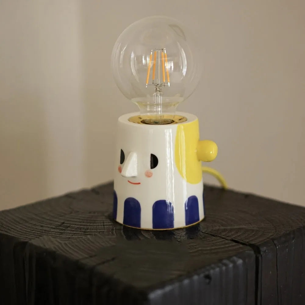 Handmade ceramic bedside lamp with ball headlight shade on wooden surface