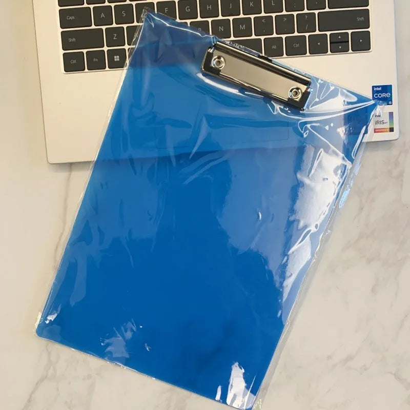 Transparent A4 plate writing board holder with metal clip, shown in blue colour on a desk.