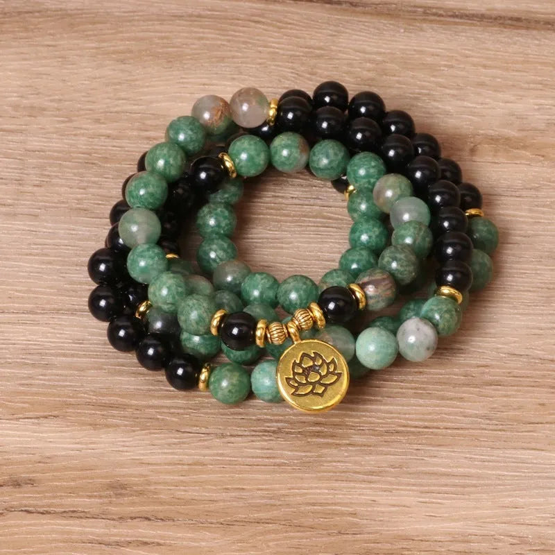 Green and black elastic beaded long bracelet with alloy construction shown on wrist