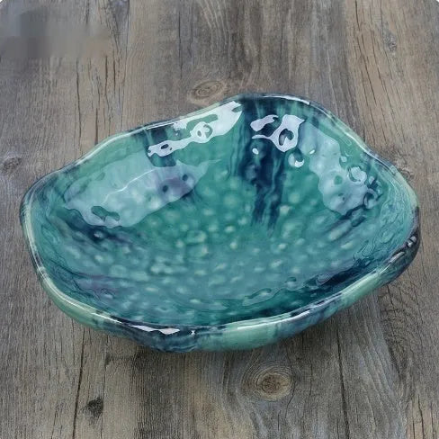 Creative Japanese ceramic sashimi bowl with irregular shape and floral decoration on table