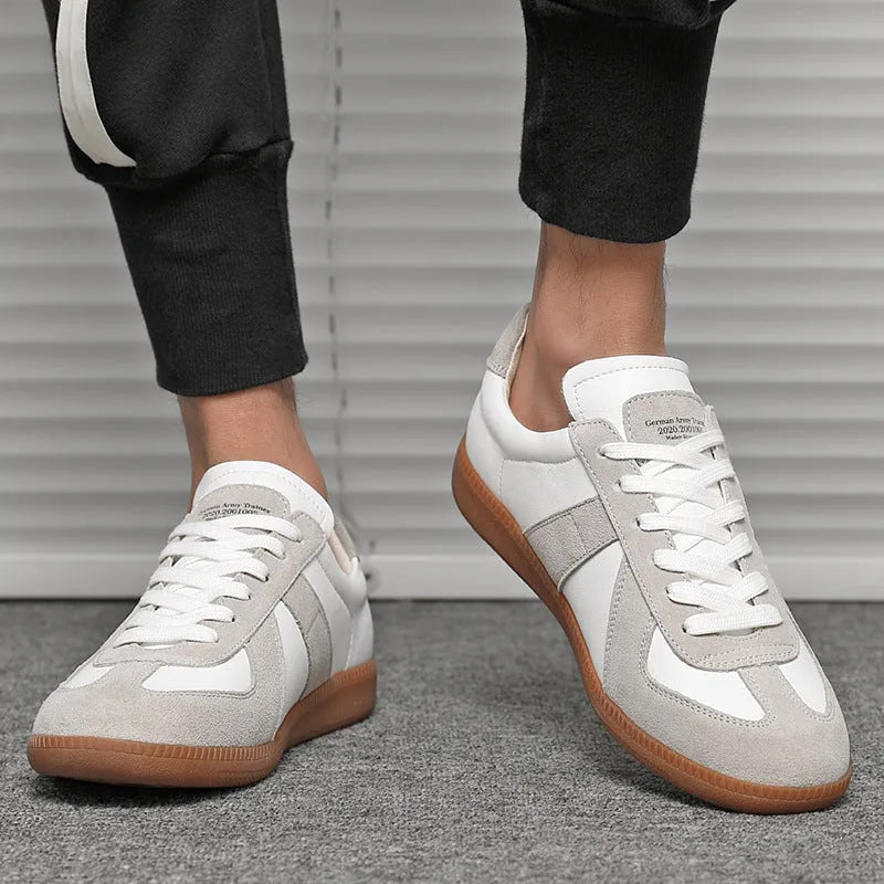 Men's low top white retro sneakers with round toe and flat rubber sole on a plain background