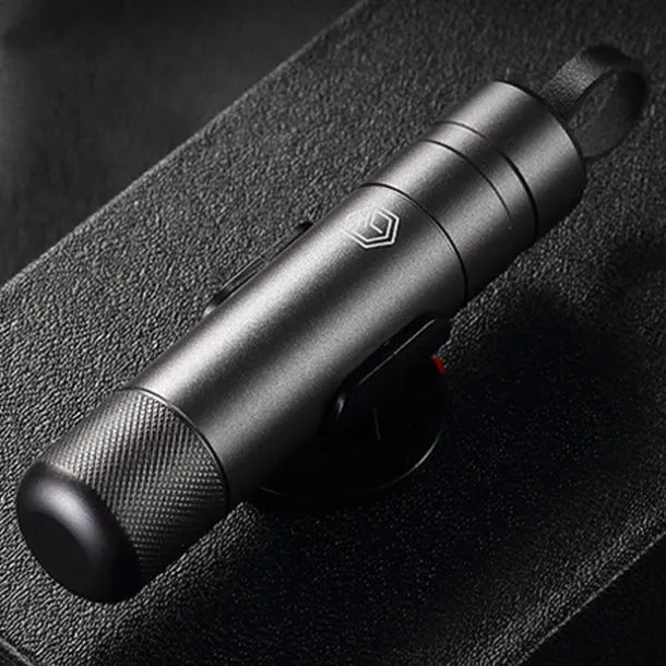 Gun grey aluminium alloy automobile safety hammer with seatbelt cutter, shown with test glass and 3M rubber base.