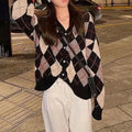 Acrylic knitted cardigan coat in light khaki colour, shown on a hanger.