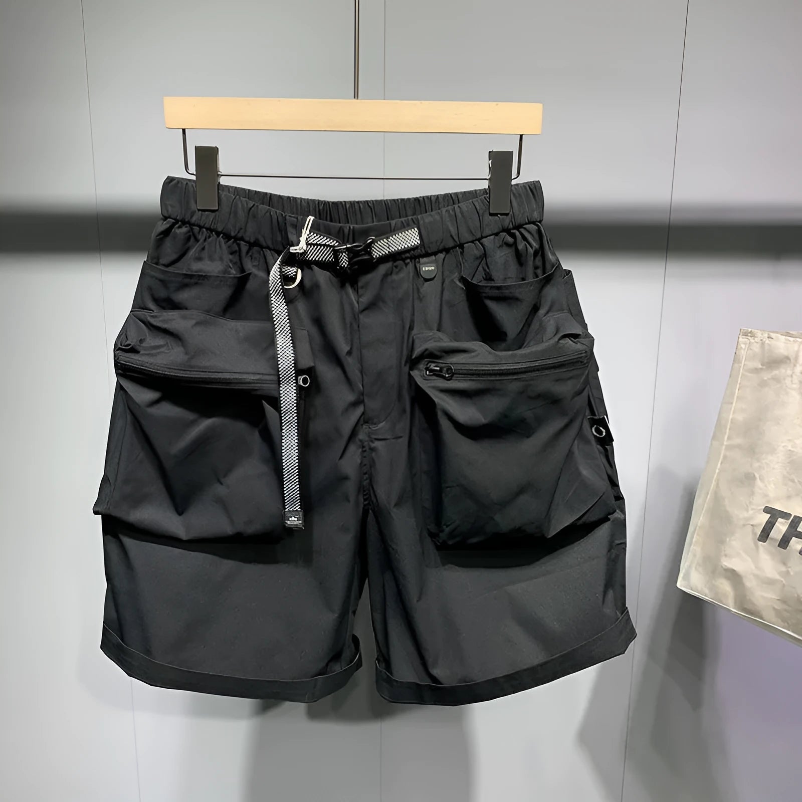Men's black loose fit work shorts with pockets and straight leg hem above knee length