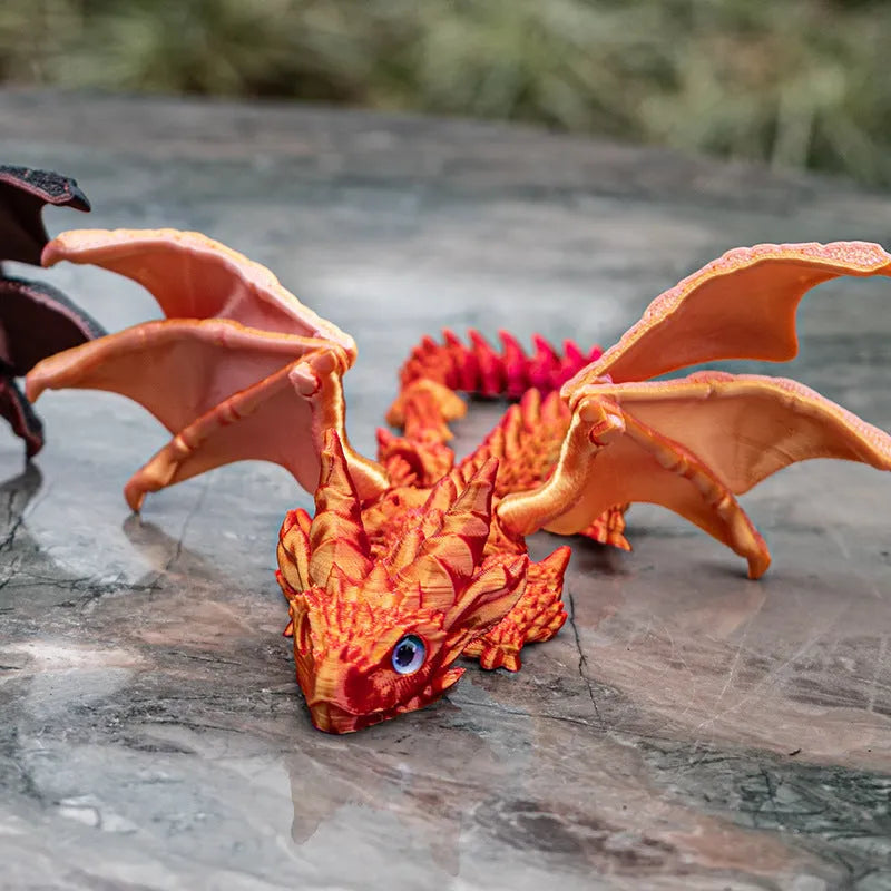 3D printed red and gold flying dragon wings decoration toy on a white background.