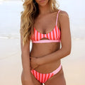 Women's black and white polka dot polyester bikini swimsuit laid flat, showing top and bottom pieces.
