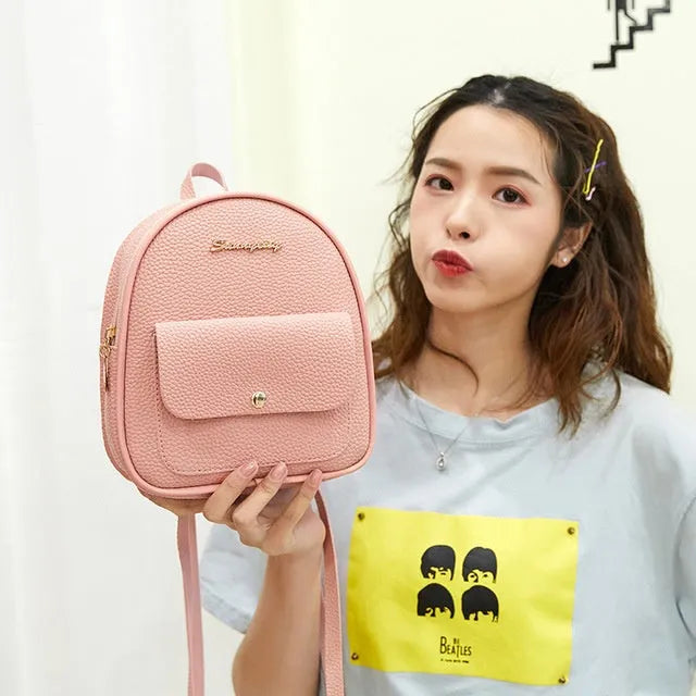 Small black PU women's shoulder backpack with zipper closure showing compact dimensions