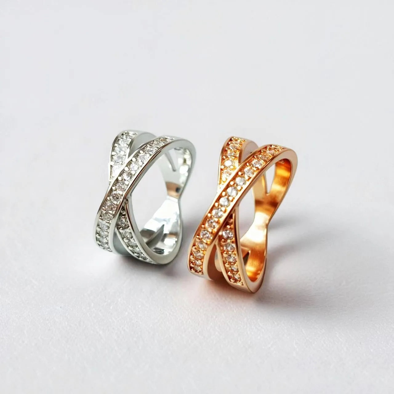 Close-up of a silver cross ring with micro-inlaid zircon details on a simple band.