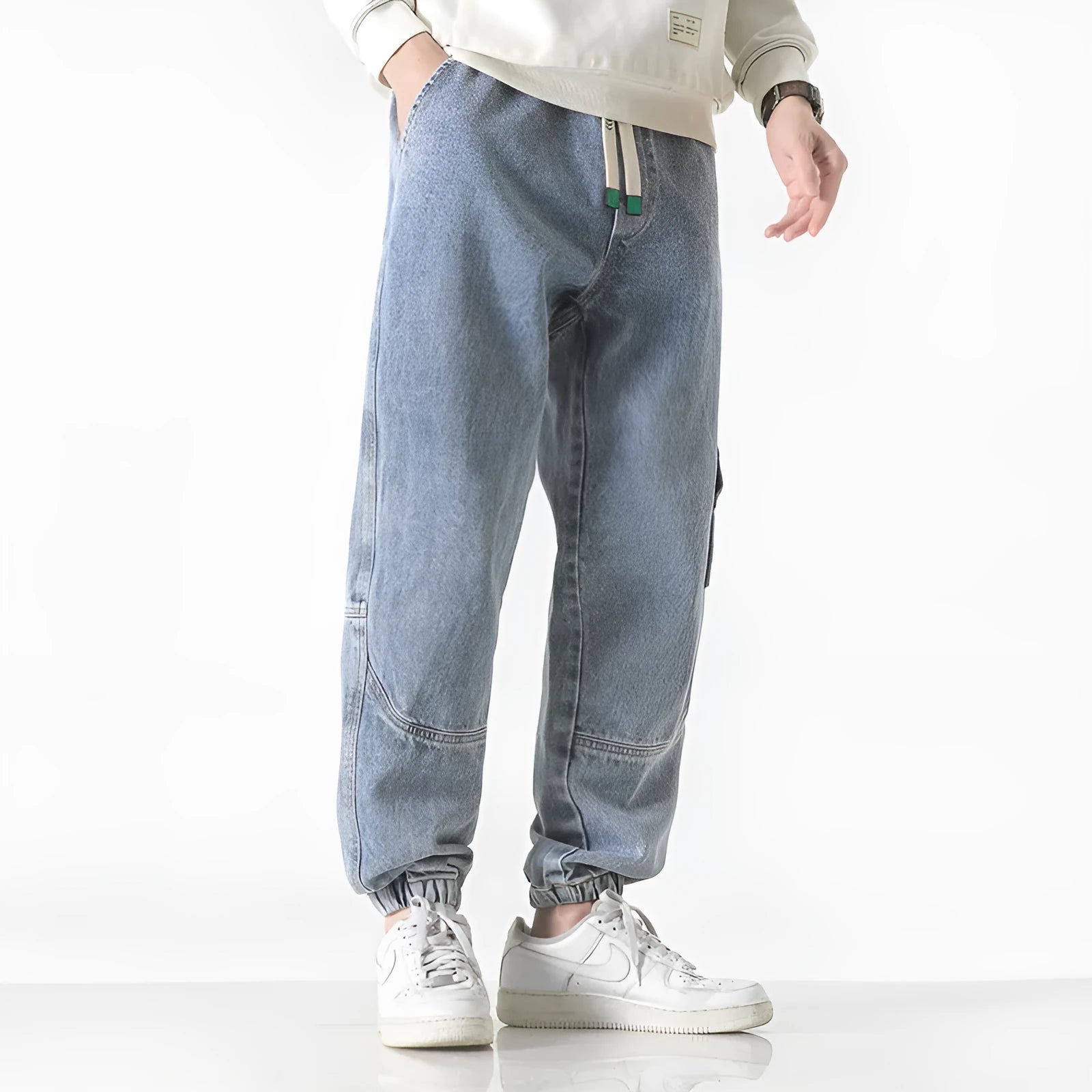 Men's loose-fit tapered cotton trousers showing tapered leg and mid-waist design in black colour