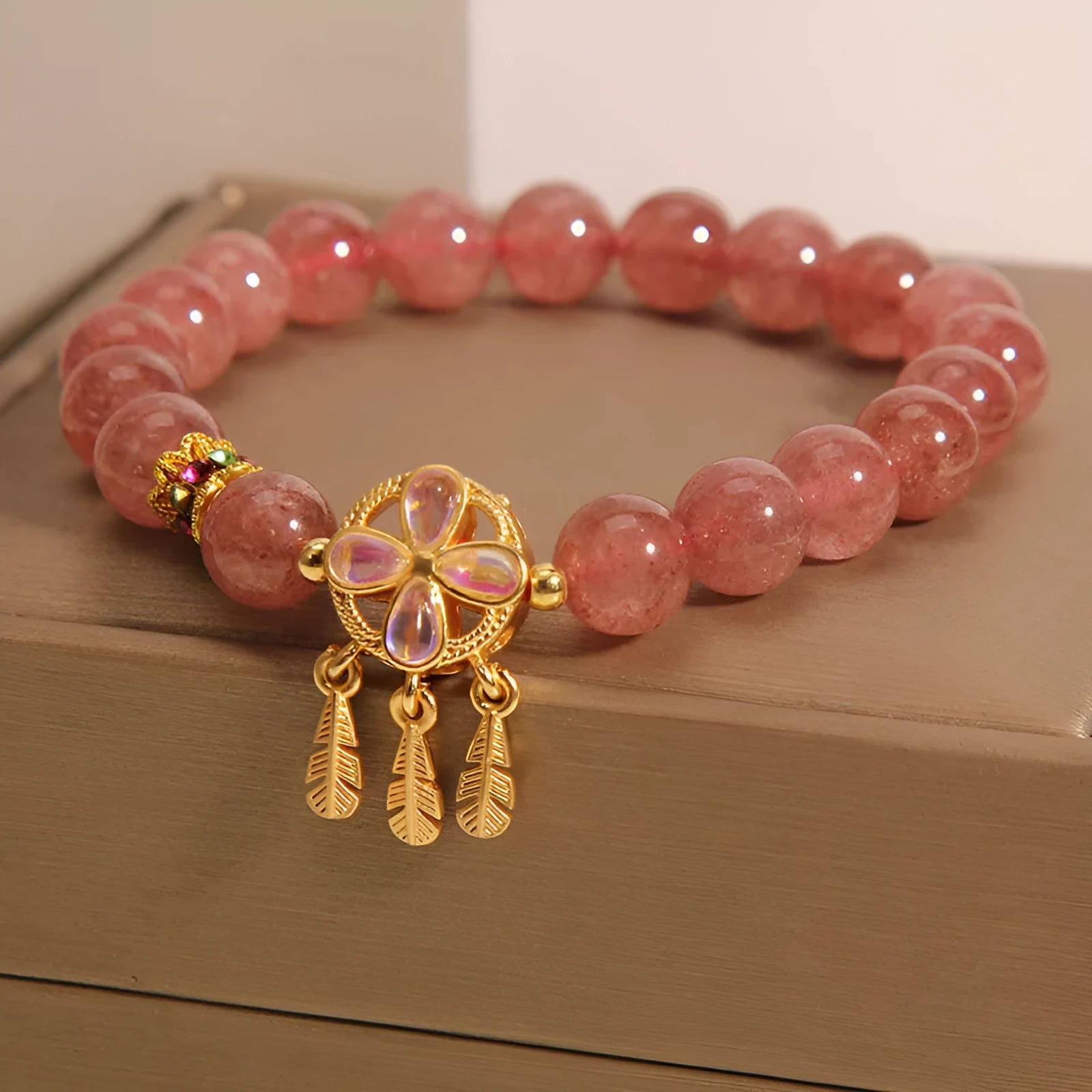 Women's strawberry quartz bracelet with four-leaf dream catcher pendant on crystal beads