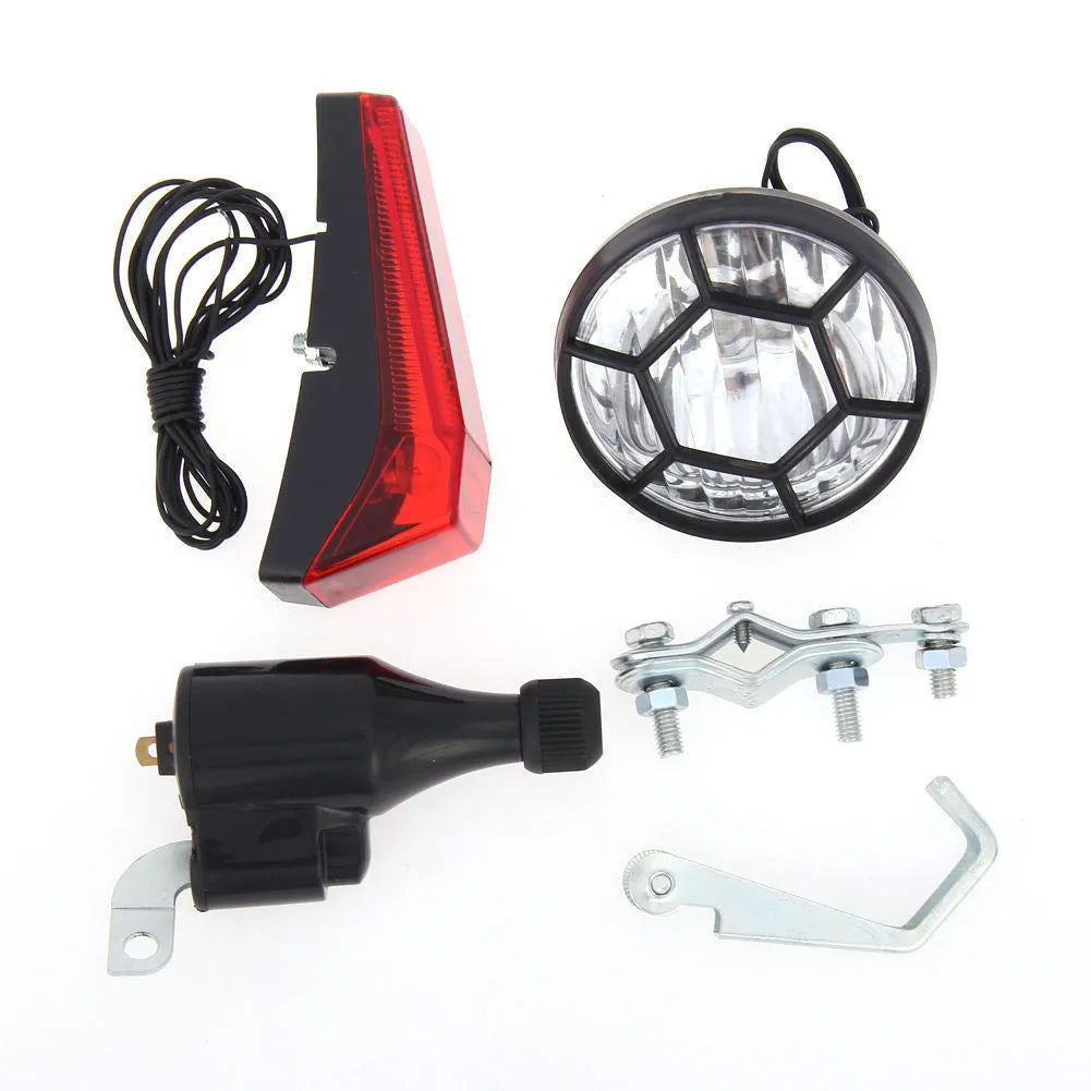 Silver bicycle dynamo generator light kit mounted on a bike fork, with wires for headlight and tail light connections.