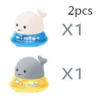 Whale-shaped baby bath toy with automatic water spray and colourful lights floating in water.
