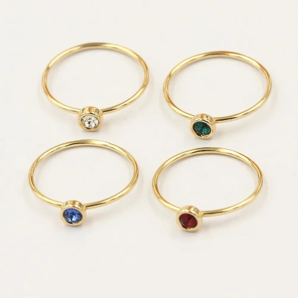 Women's 14K gilded copper knuckle ring with zircon accents in green, shown on a model's finger.