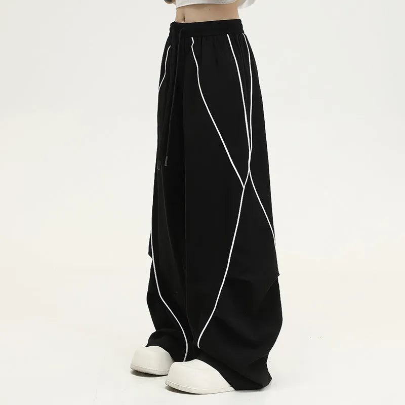 Black striped pleated hip hop sports wide-leg pants on hanger showing loose fit and mid-waist design