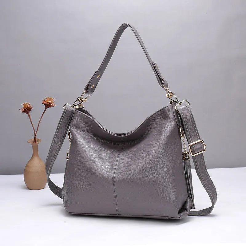 Genuine leather crossbody bag in a vertical square shape with visible sewing lines and a crossbody strap.