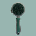 Two-sided silicone cat hair brush showing retractable slicker brush and octopus-teethed massager sides on green background