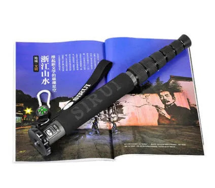 Black carbon fibre SLR camera monopod fully extended, showing its 6-section telescopic design.