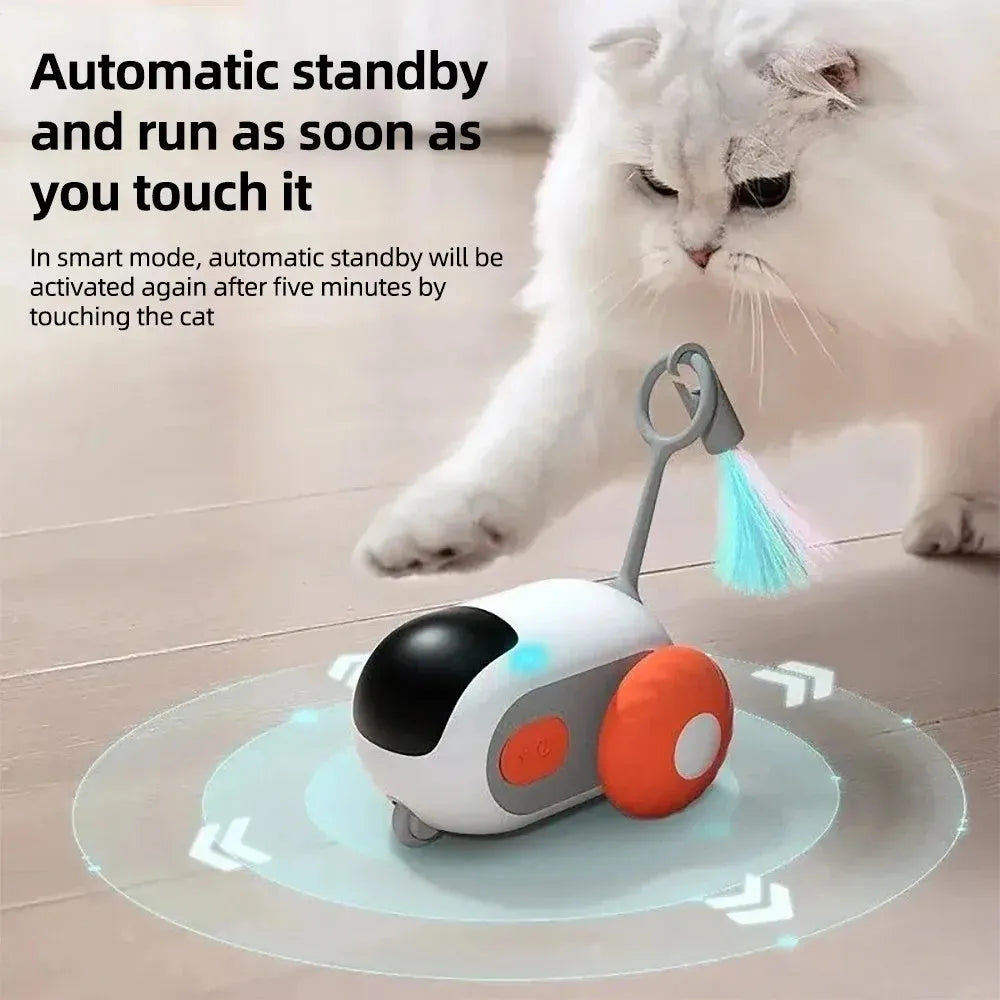 Blue and orange smart remote control cat toy car with feather teaser attachment on a home floor.
