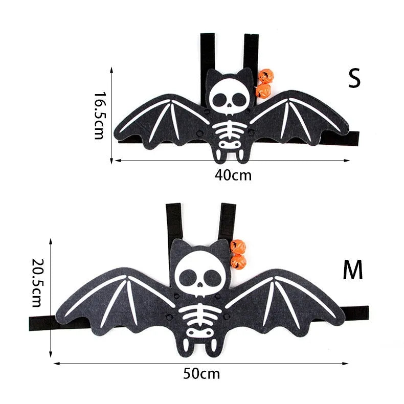 Black cat wearing an orange felt batwing Halloween costume with bell.
