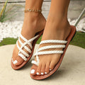 Women's white woven clip-toe flat sandals with a rubber sole on a neutral background.