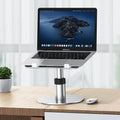 Silver aluminium car laptop stand with adjustable height and rotating base on a car seat.